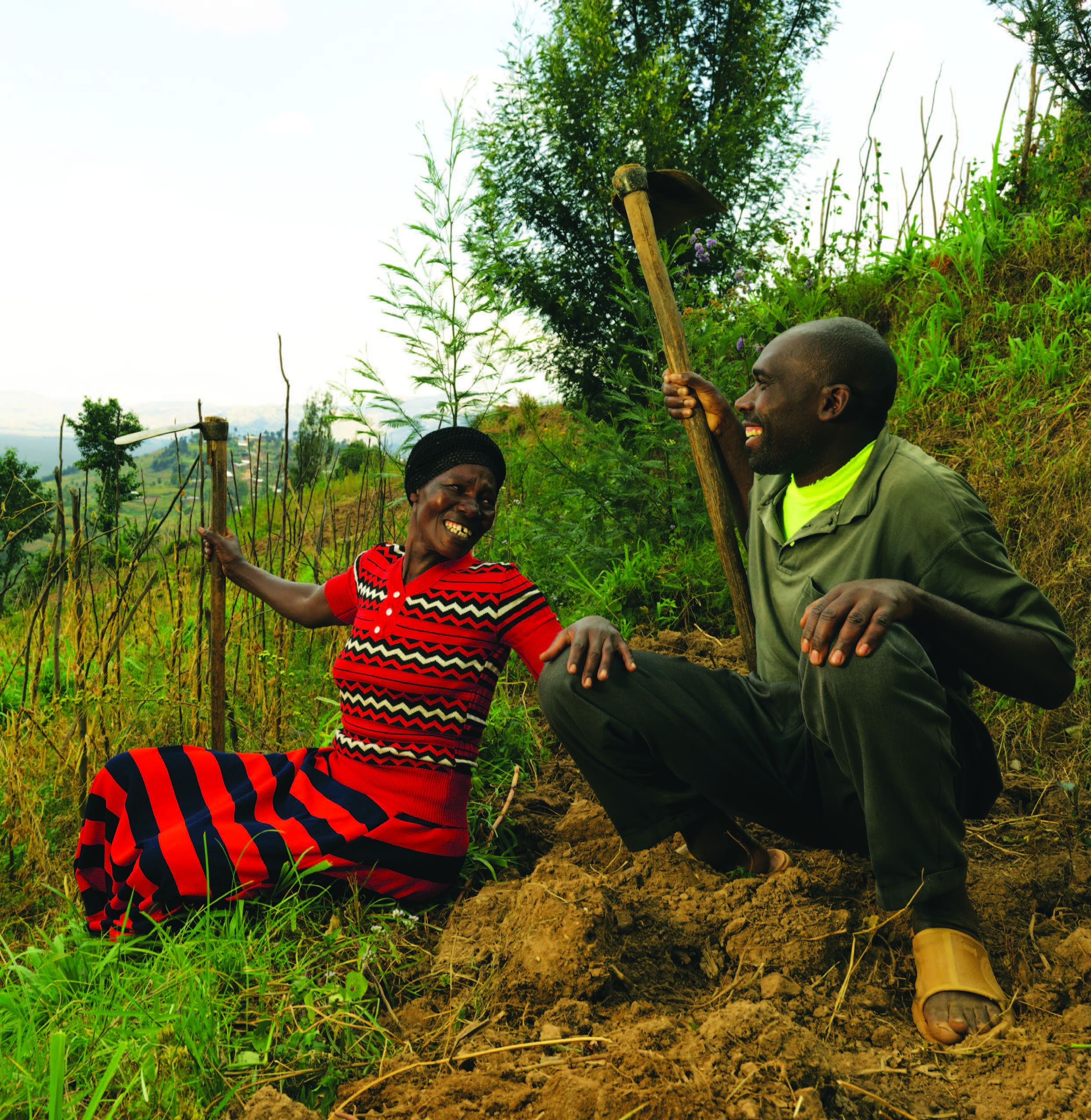 African Man And Women Farmers Sat In A Field Smiling