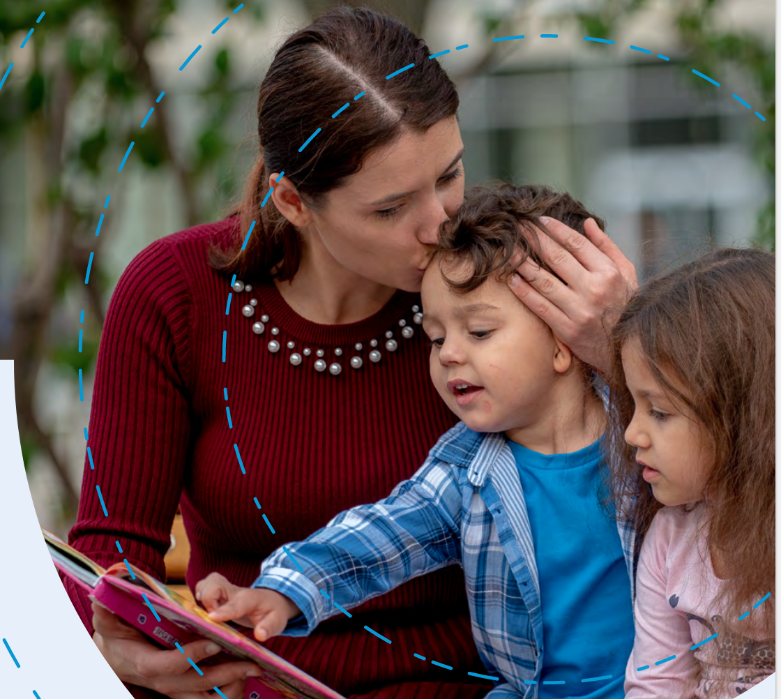 A Woman Holding Two Children, A Boy And A Girl. She Is Kissing The Boy On The Forehead.