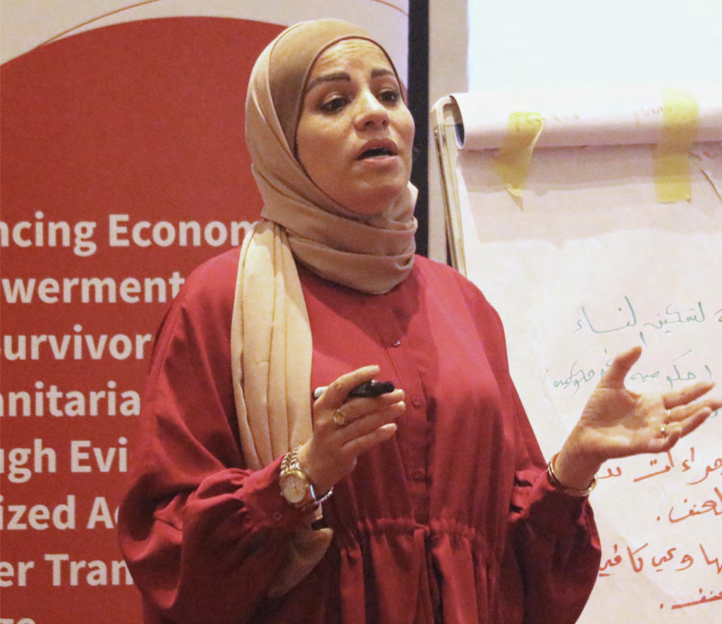 A woman wearing a hijab presenting in front of an audience